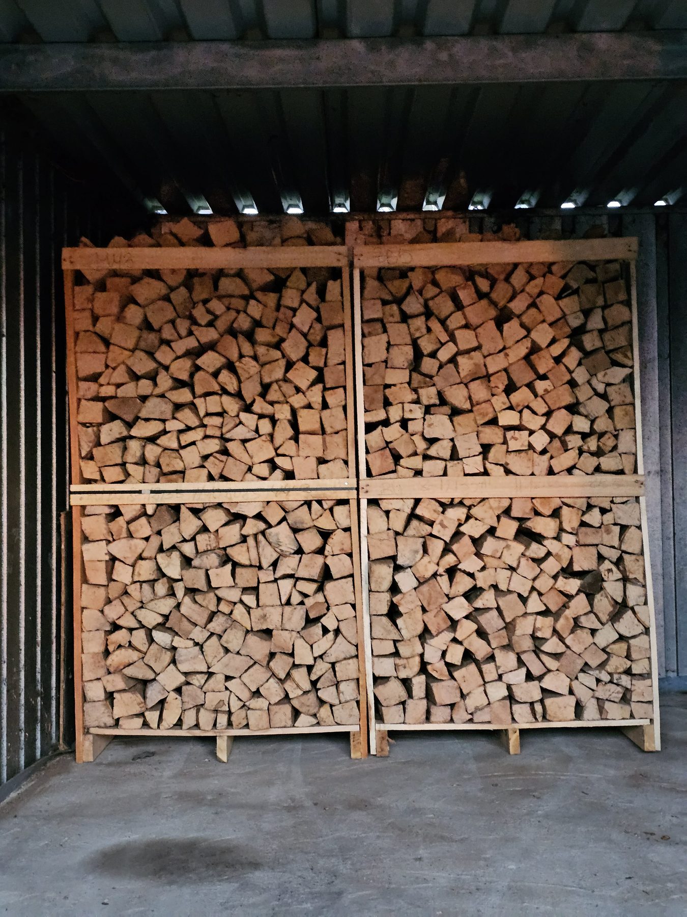 Gestapeltes Kaminholz in Holzboxen