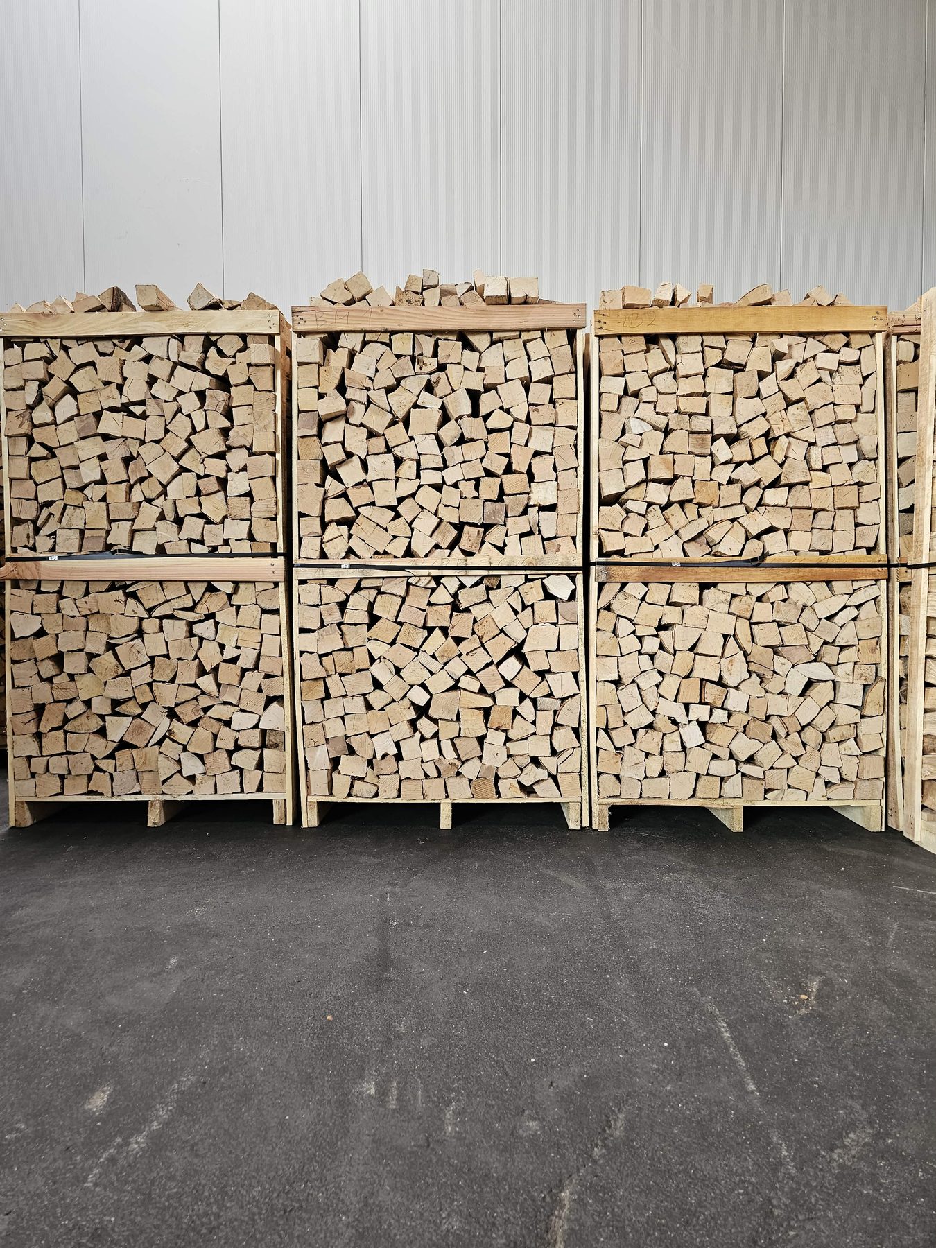 Wand aus palettierten Kaminholz-Boxen